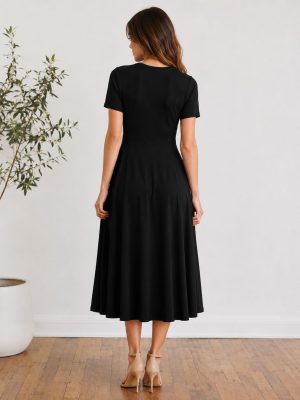 Ženska nosi elegantno midi obleko. Obleka ima ženstven kroj, ki lepo poudari silhueto,
